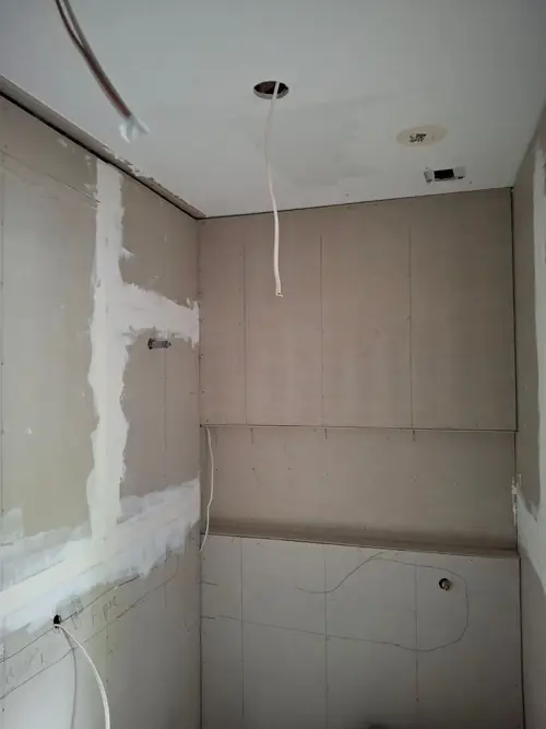 Creation of a new bathroom in the existing structure . The wall has been cut and reframed to install a window . The walls have been straightened , framed and the villaboard.