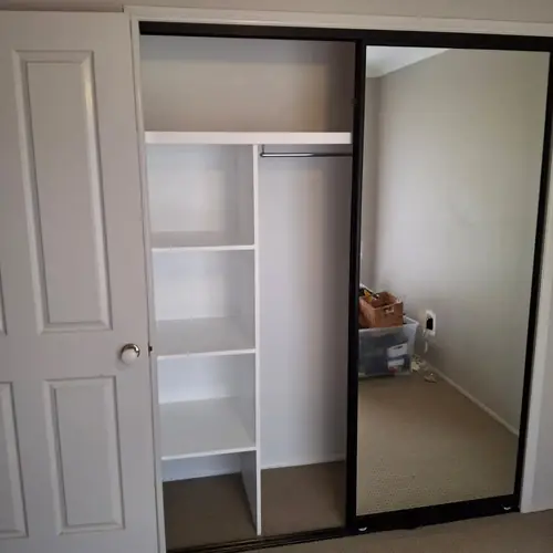 We've replaced those wardrobe swing doors with sliding doors. We've also built a new set of shelves in each one.