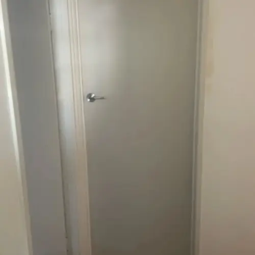 Replacement of the sliding door with a swing door. The handle has been installed to that height to match the other doors. The light switch has been moved on the other side. The old light switch hole has been patched.