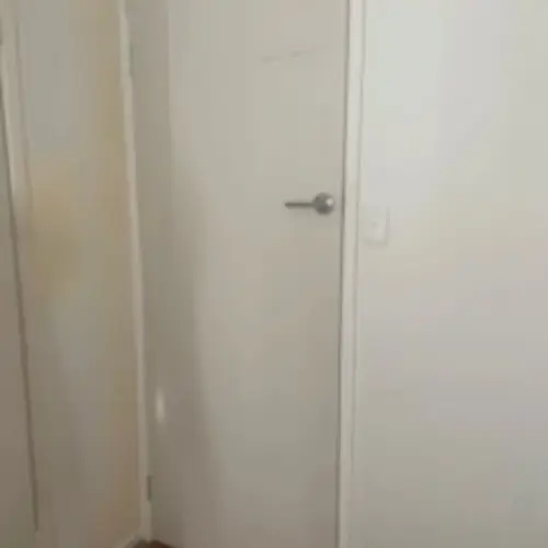 Replacement of the sliding door with a swing door. The handle has been installed to that height to match the other doors. The light switch has been moved on the other side. The old light switch hole has been patched.